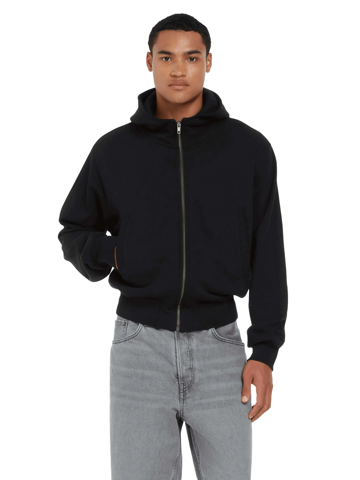 Man wearing the organic bomber jacket hoodie in Black with grey jeans, front view