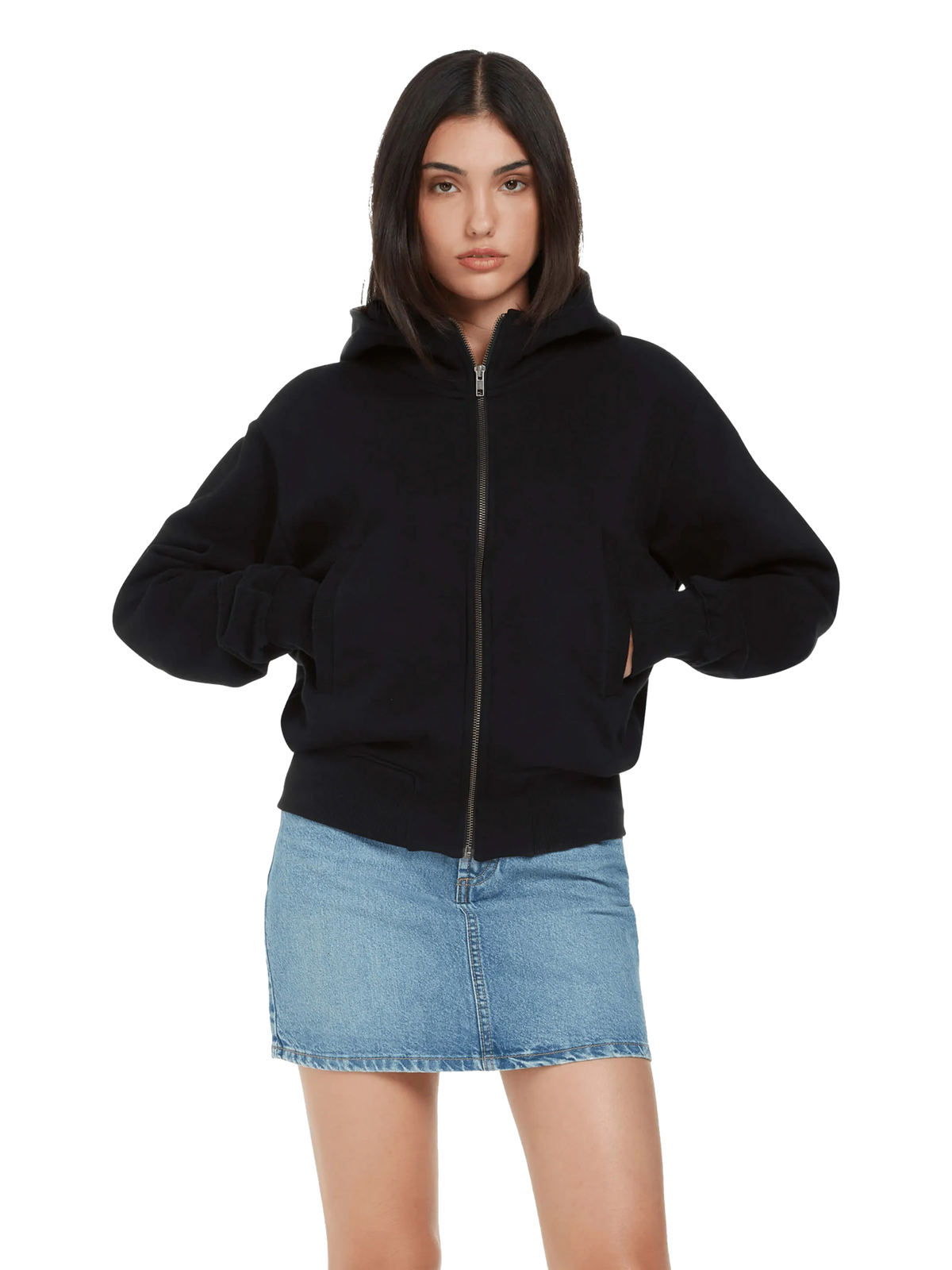 Woman wearing the organic bomber jacket hoodie in Black with a denim skirt, front view