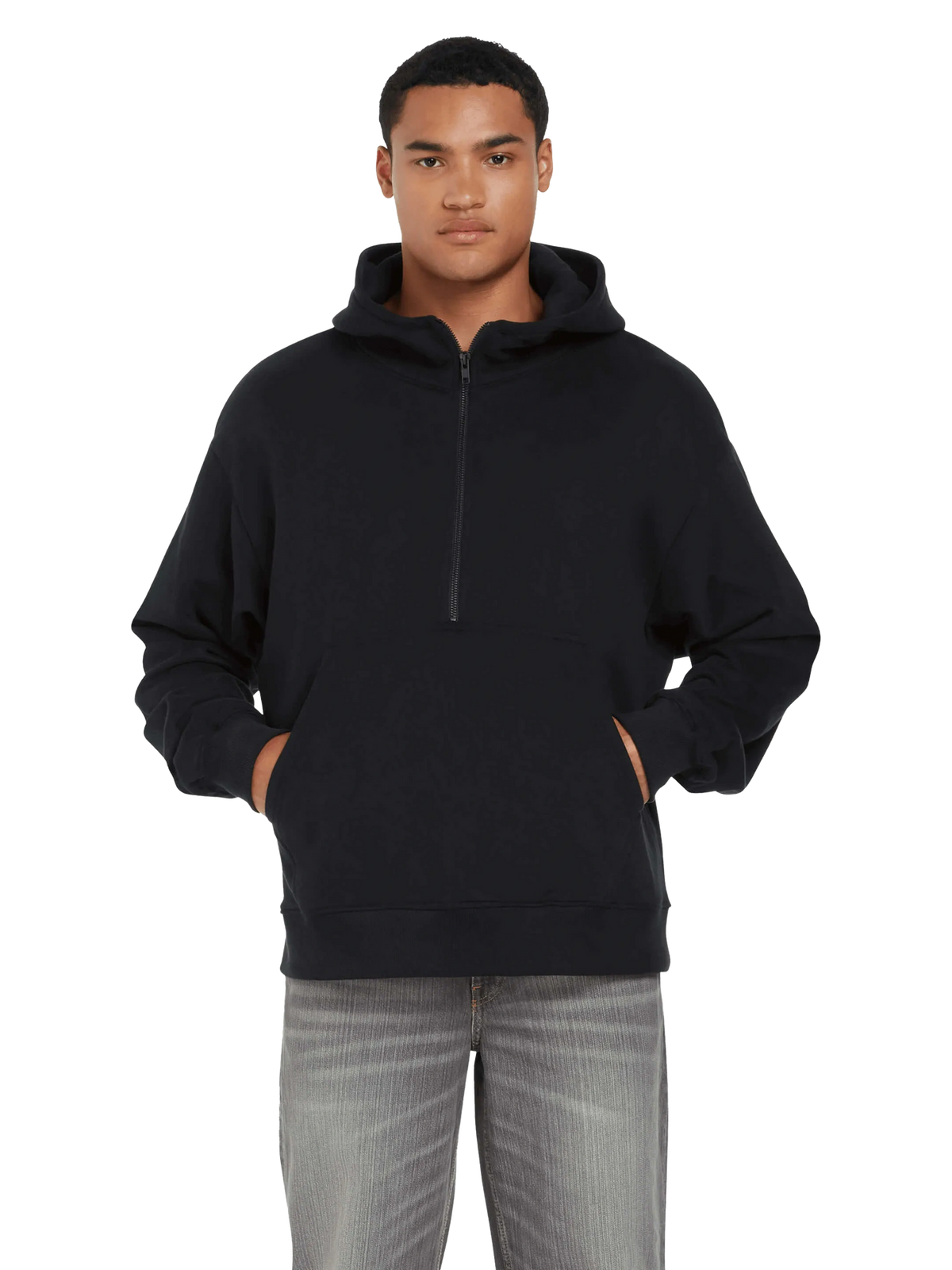 Model wearing the unisex organic half zip hoodie in black with hands in pockets, front view