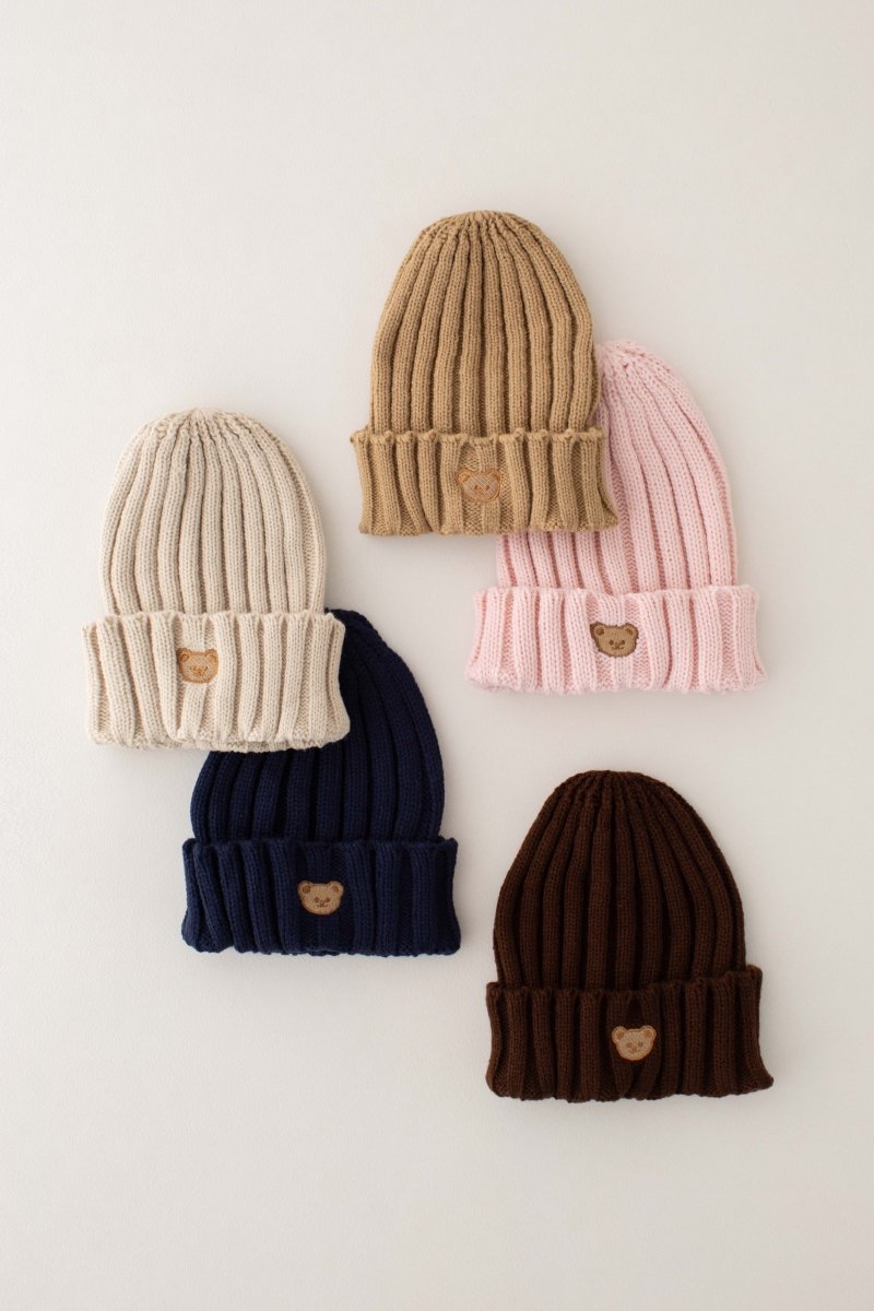 Five kids' embroidered bear knitted beanie hats in assorted colours, flat lay