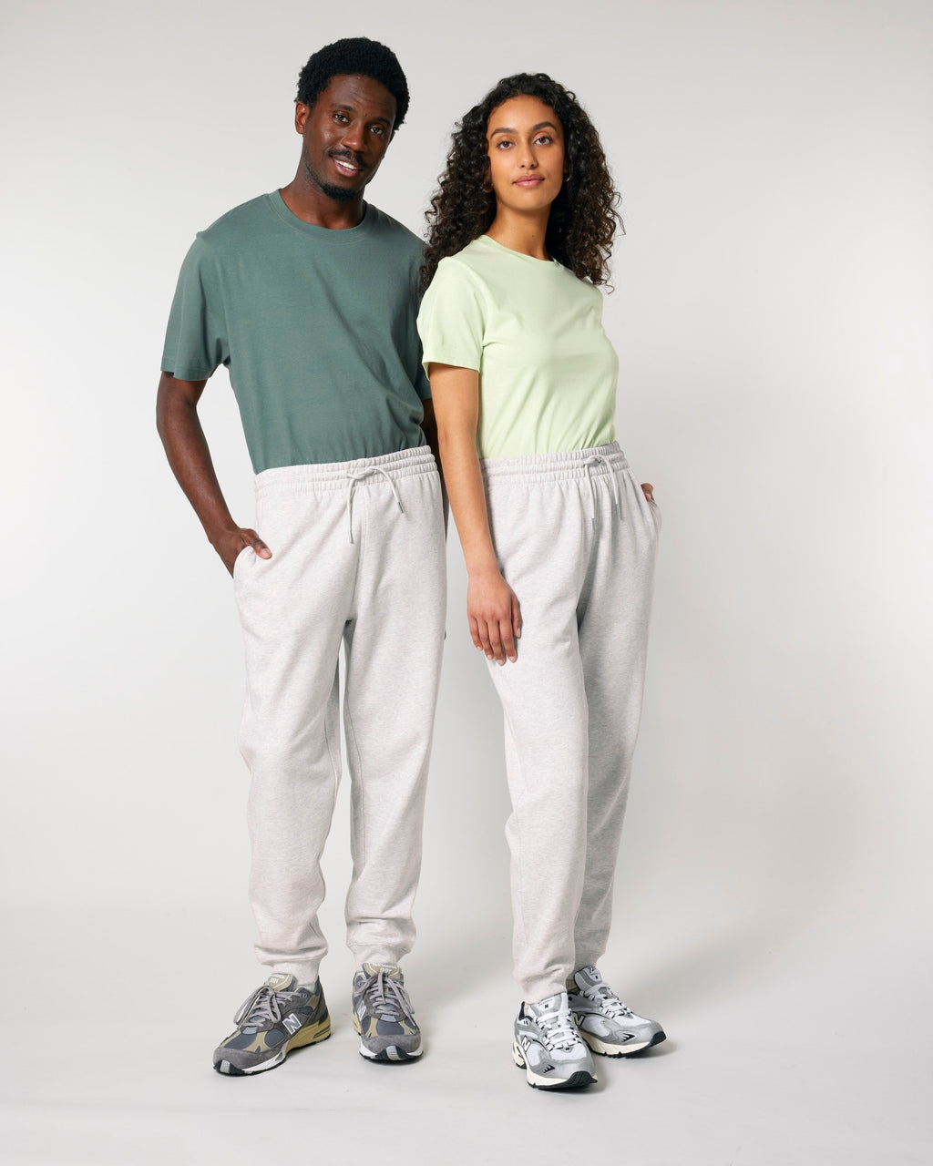 Two models wearing unisex organic cotton sweatpants in Cool Heather Grey, full-length view