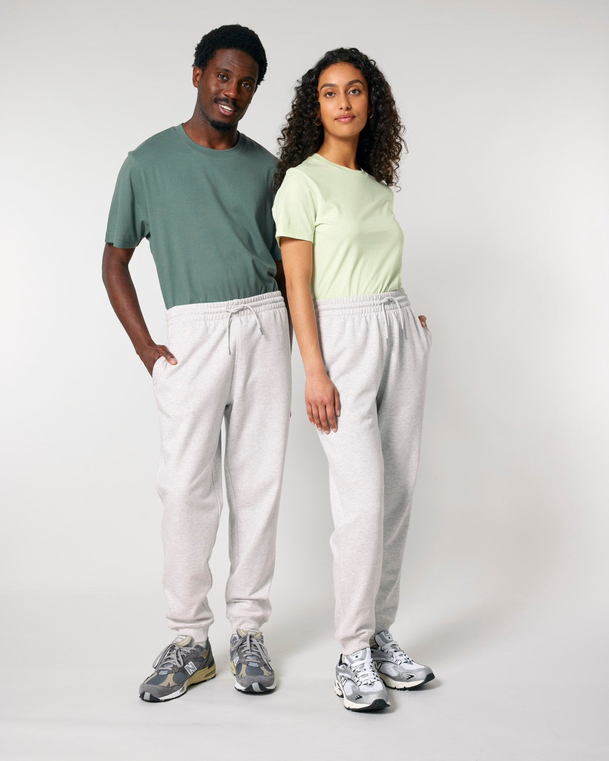 Two models wearing unisex organic cotton sweatpants in Cool Heather Grey, full-length view