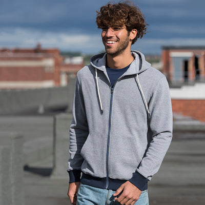 Man wearing the recycled contrast zip hoodie in Heather Grey/ Navy on a rooftop