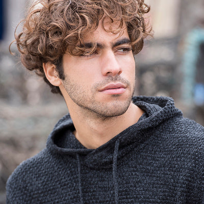 Close-up of a man wearing the knitted recycled hoodie in Charcoal/ Black
