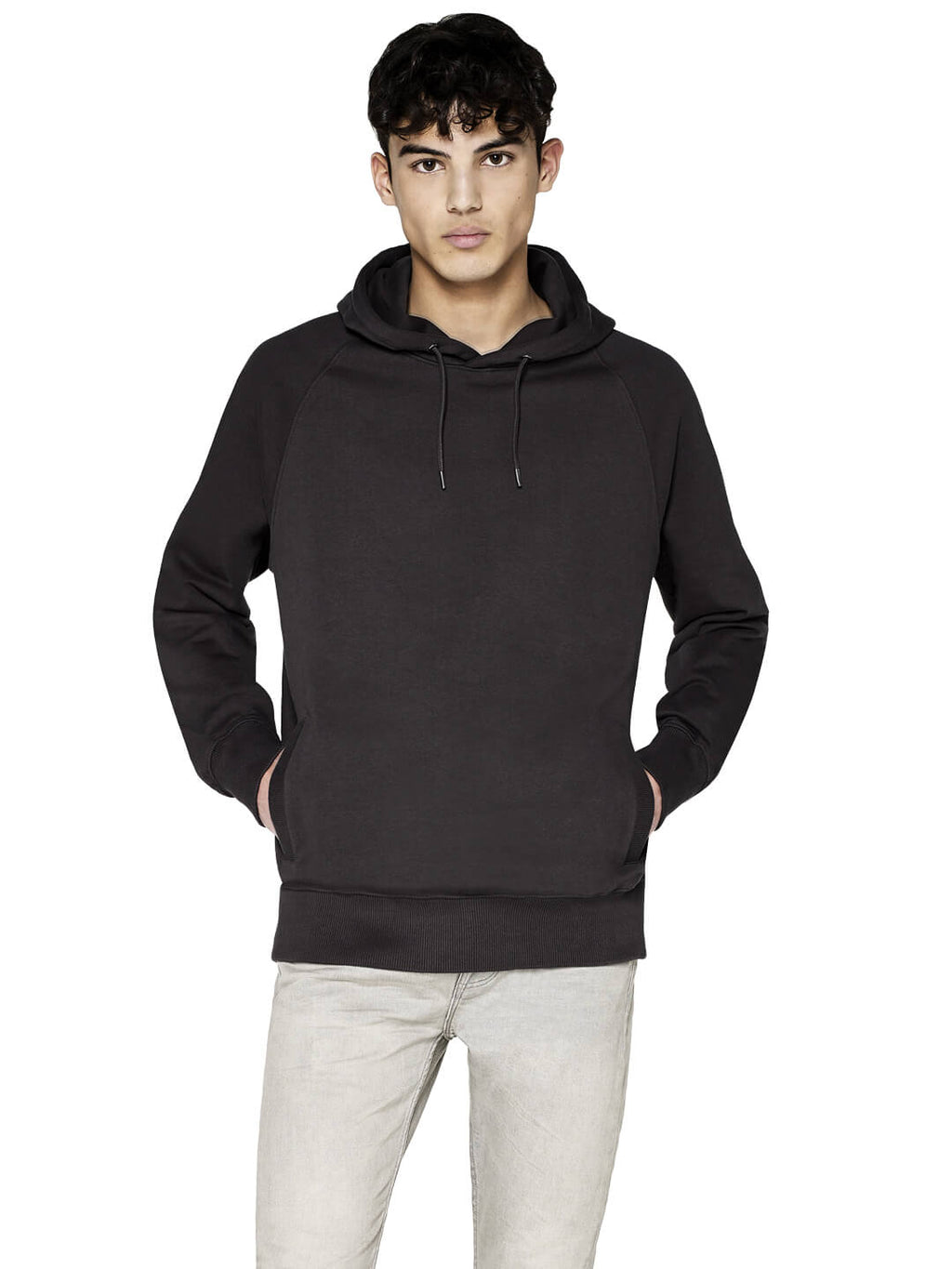 Unisex heavy organic cotton raglan hoodie worn by a model, hands in pockets