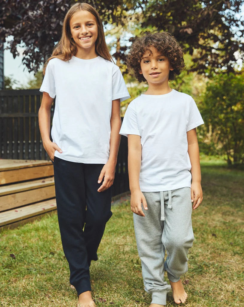 Two children wearing kids' Fairtrade organic sweatpants in Navy and Sport Grey