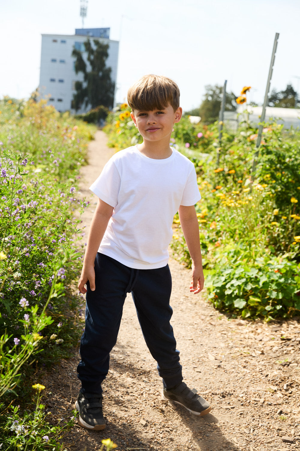 Child wearing kids' Fairtrade organic sweatpants in Navy, outdoors