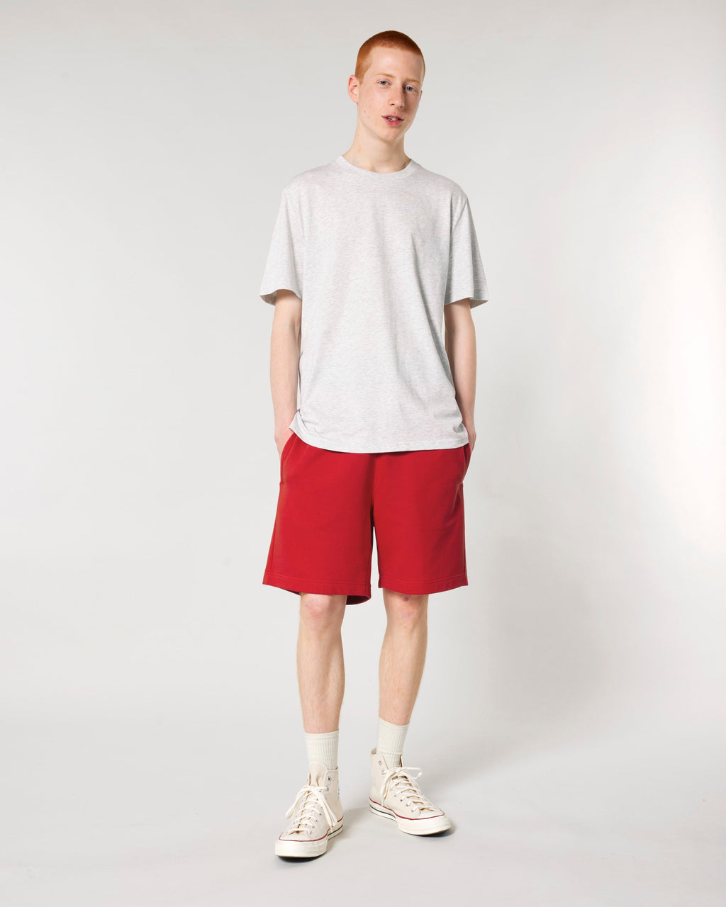 Model wearing the unisex organic cotton French terry jogger shorts in Red, front view