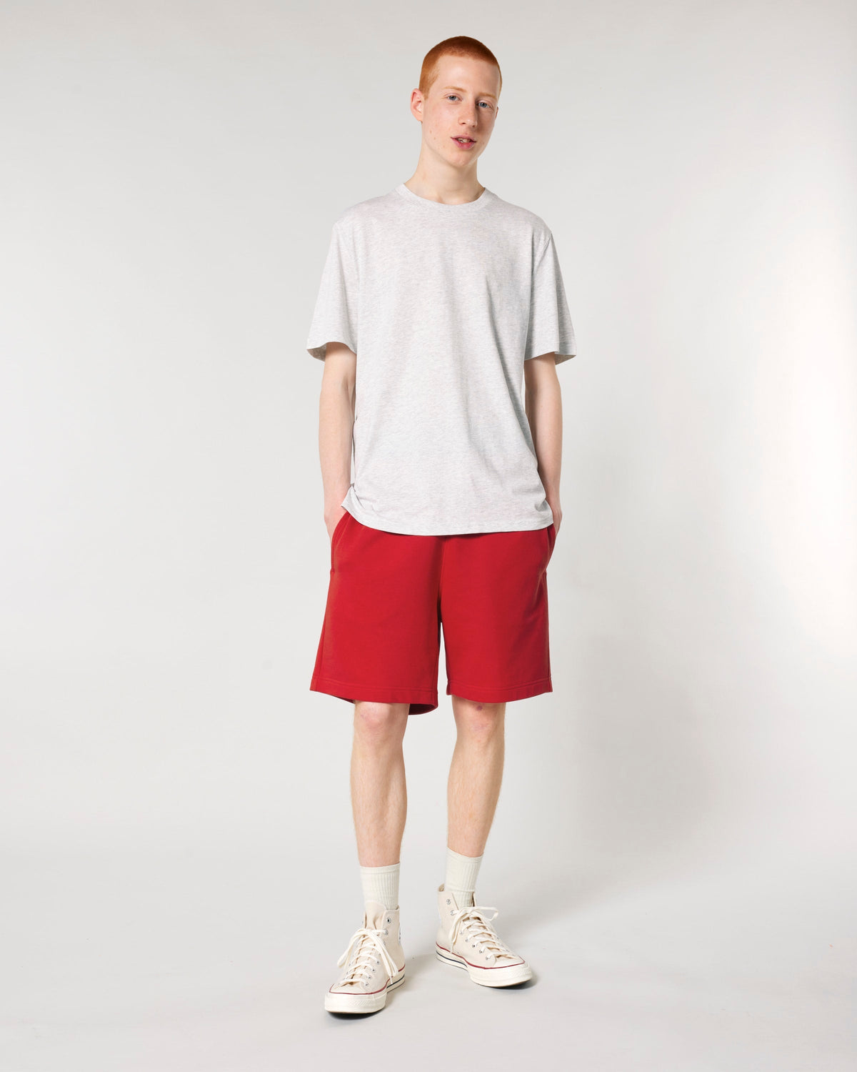 Model wearing the unisex organic cotton French terry jogger shorts in Red, front view