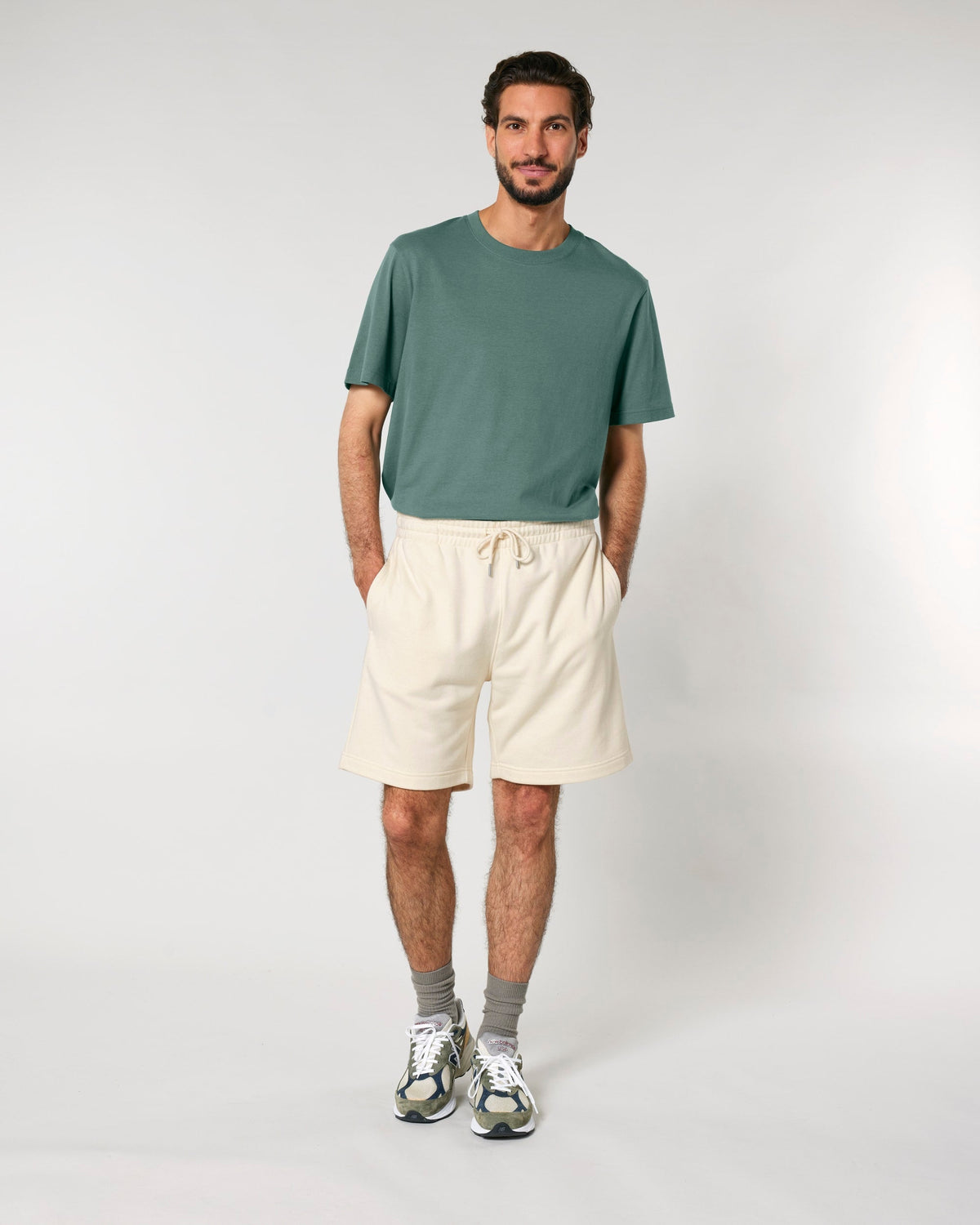 Model wearing the unisex organic cotton French terry jogger shorts in Natural Raw, front view
