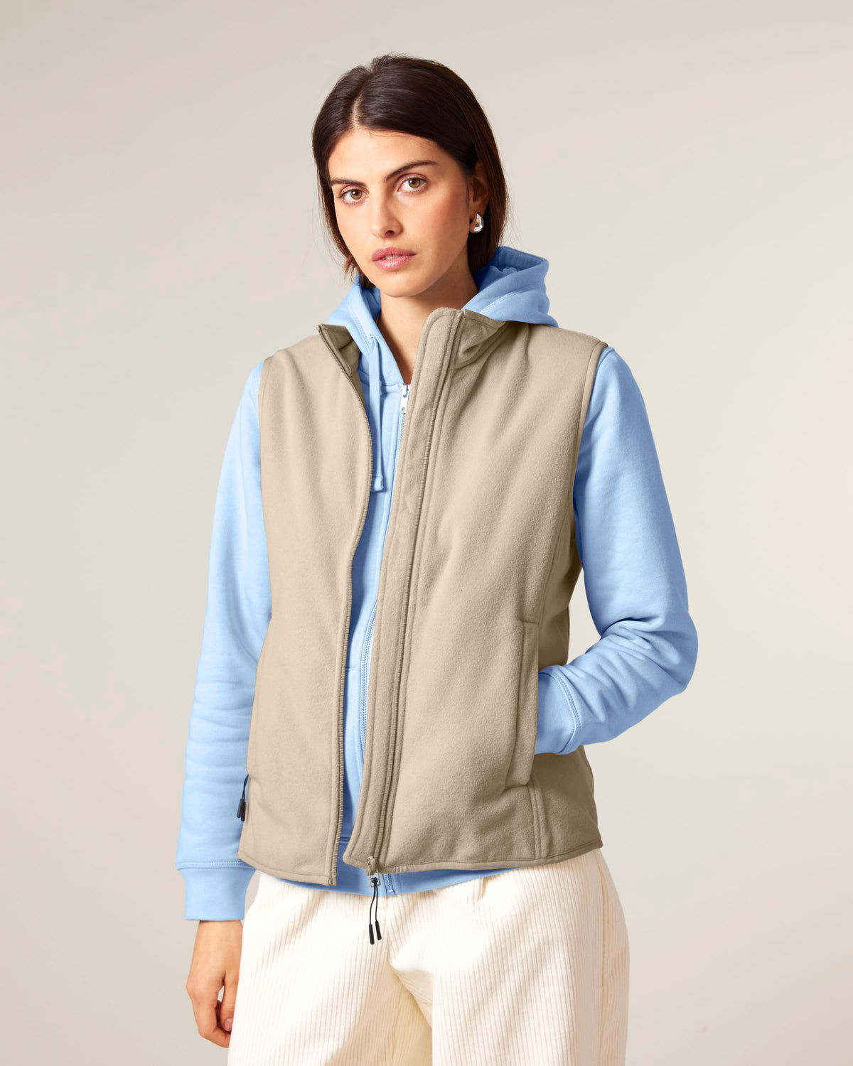Model wearing the women's recycled fleece bodywarmer in Desert Dust, front view