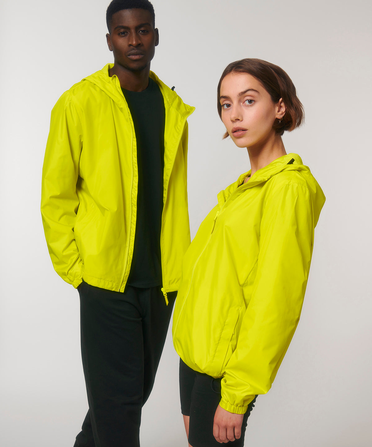 Man and woman wearing the recycled lightweight waterproof jacket in Lime Flash